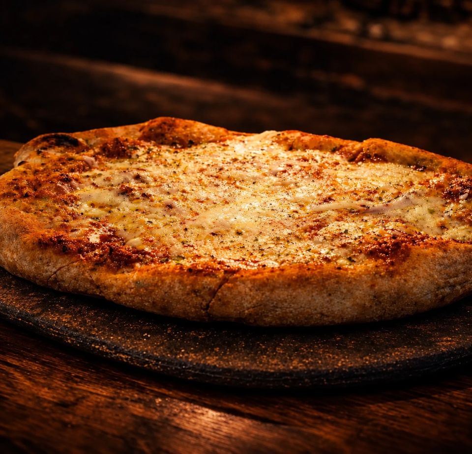 Pizza de muzzarella gratinada con bordes dorados, sobre una piedra.